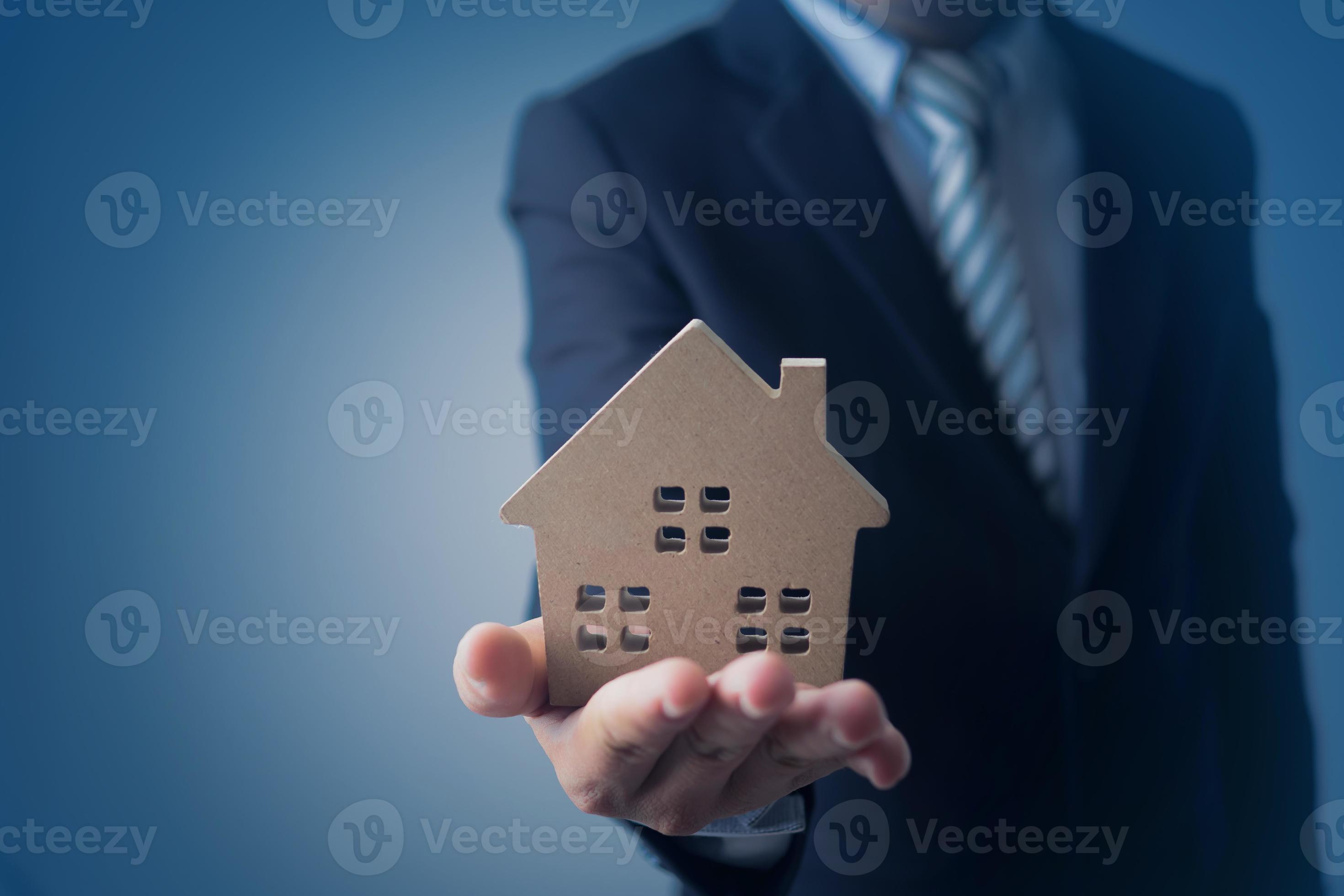 modello di casa uomo d'affari su sfondo blu scuro foto