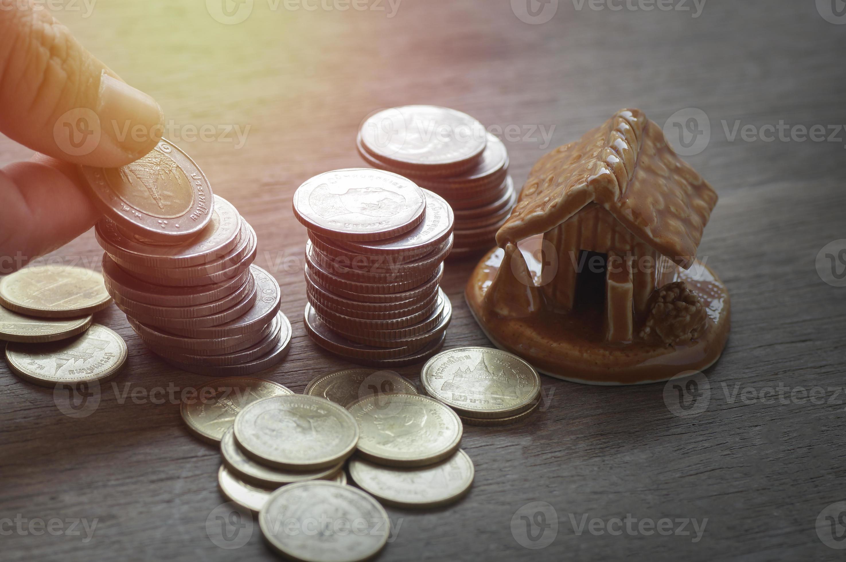 monete con un piccolo modello di casa foto