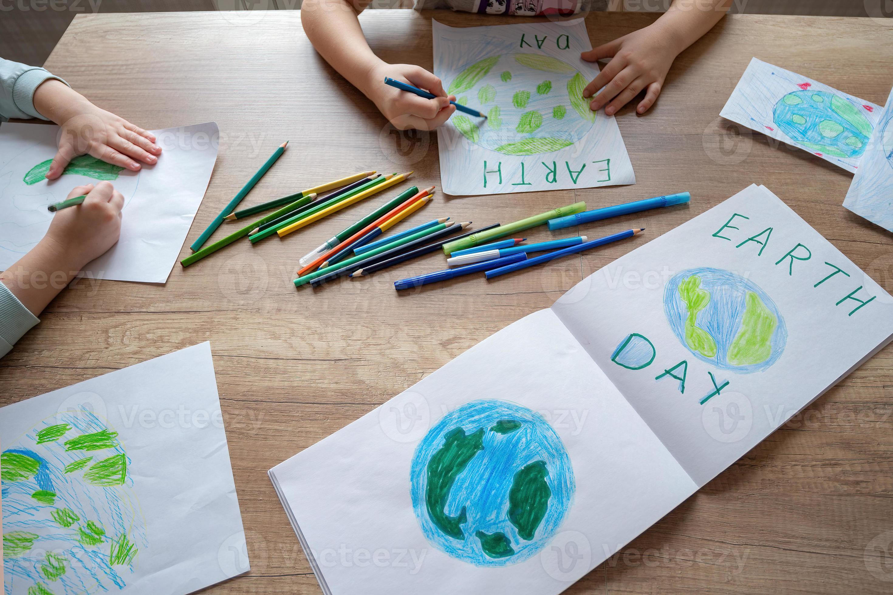 bambini disegnare il pianeta terra con matite e pennarello penne su album  lenzuola per terra giorno a loro casa tavolo. 21152845 Stock Photo su  Vecteezy