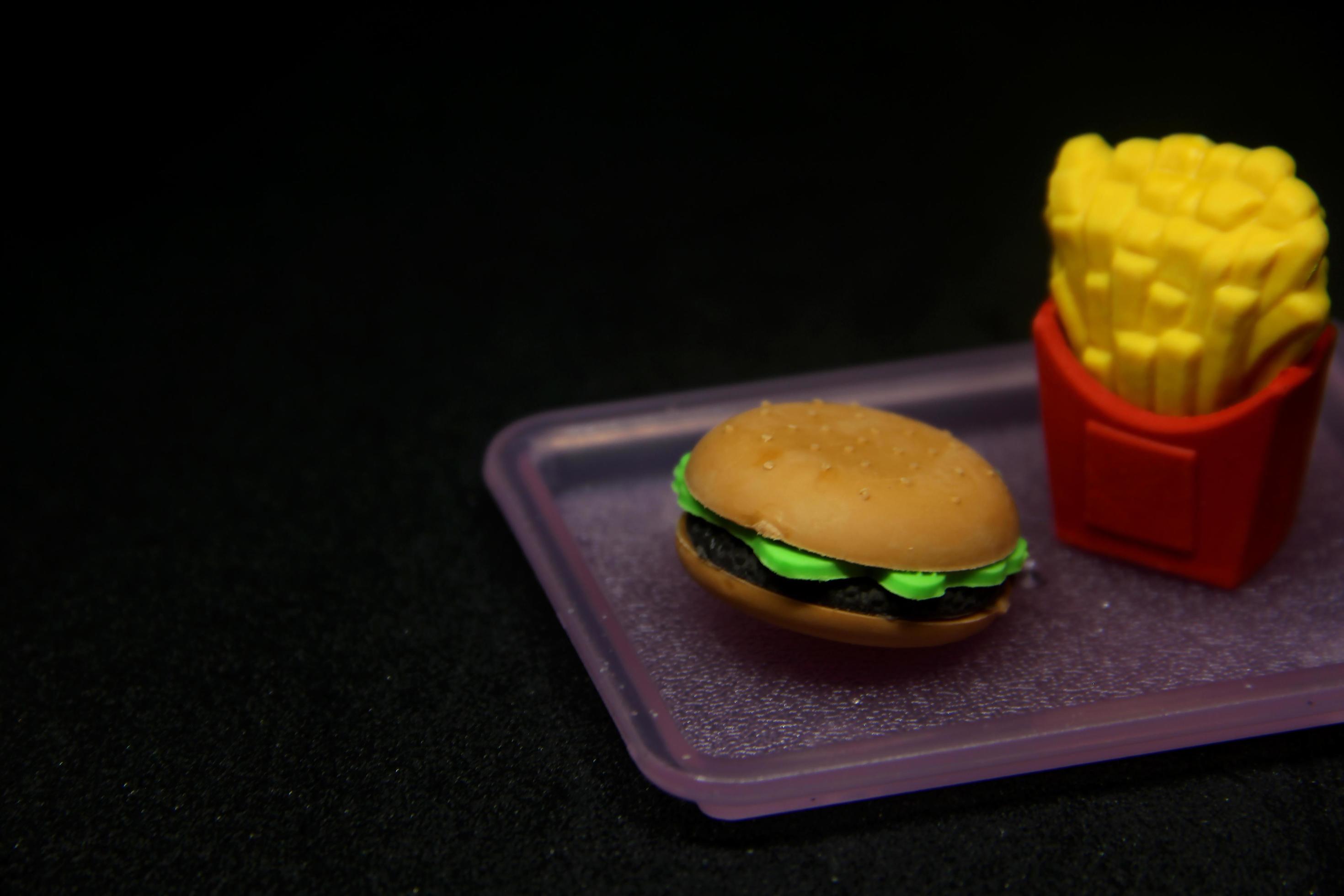 Hamburger e patatine fritte sagomato gomma. scuola o ufficio stazionario  attrezzo forniture con Rifiuto cibo forma. isolato foto su buio nero  sfondo. 21549246 Stock Photo su Vecteezy