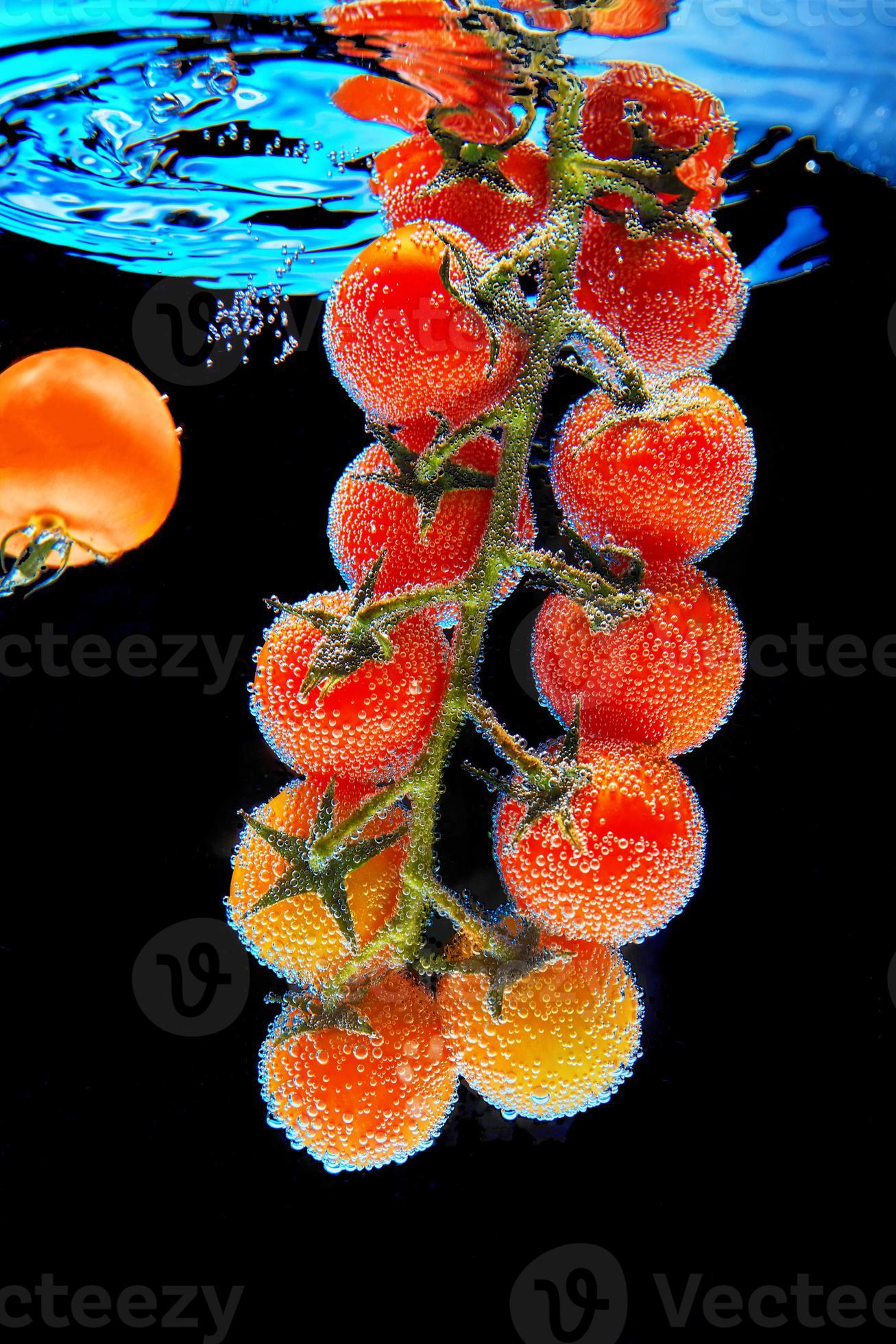 ramo con pomodorini rossi con foglie verdi ricoperte di bolle di gas foto