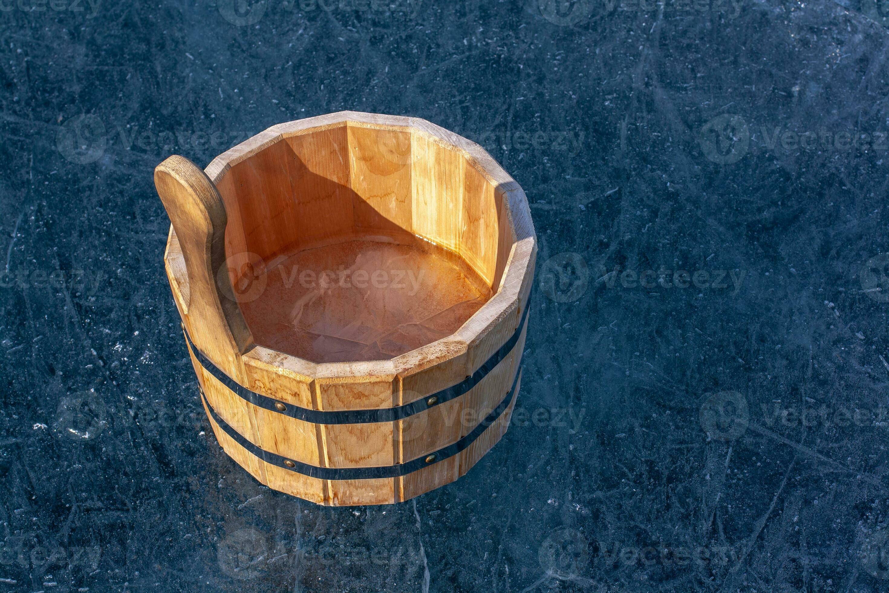 un' di legno vasca con ghiaccio dentro è in piedi su il ghiaccio con crepe.  ferro serraggio anelli Collegare parti di il vasca. soleggiato.  orizzontale. 24791080 Stock Photo su Vecteezy