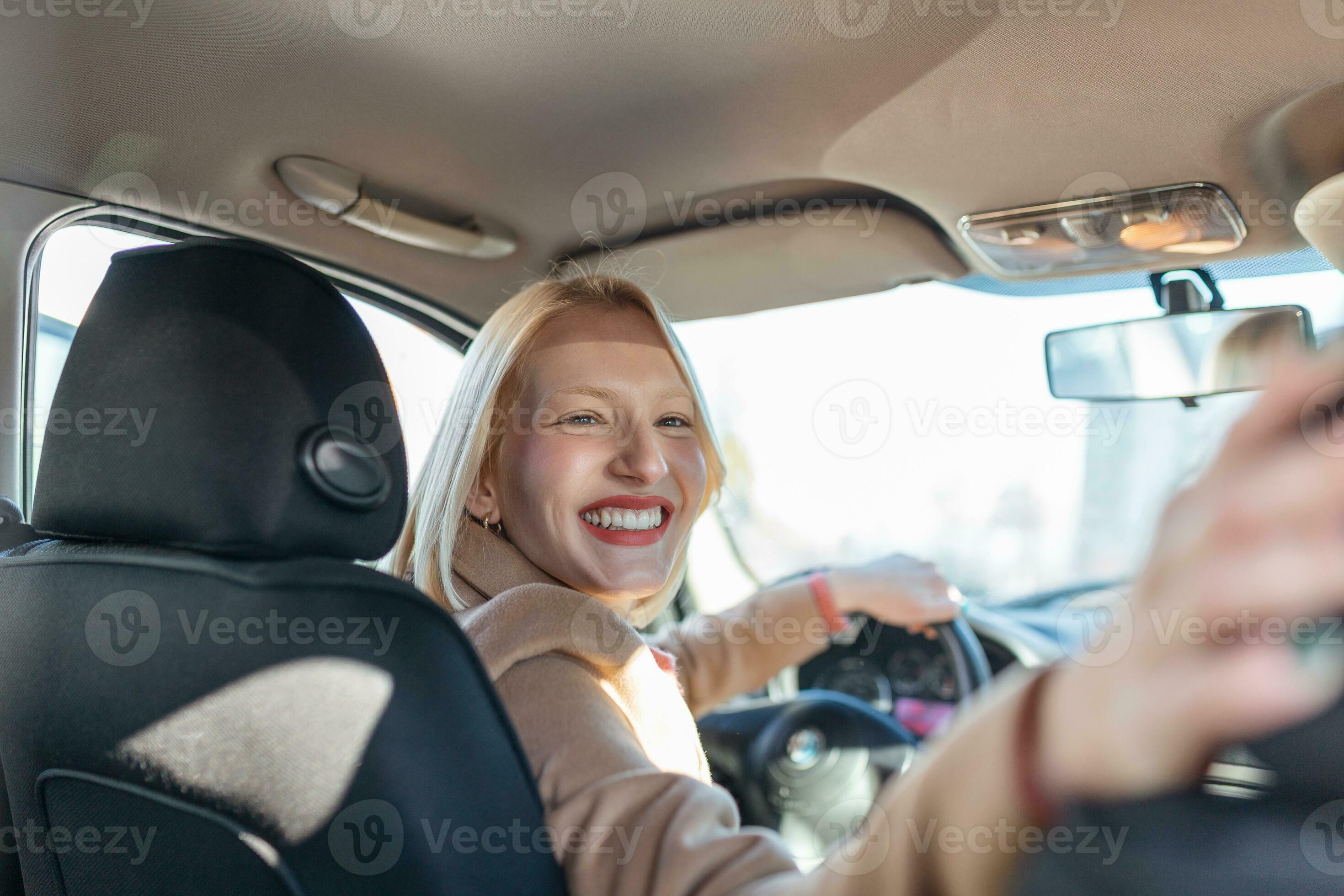 donna nel auto interno svolta in giro guardare a viaggiatori nel indietro  posto a sedere idea Taxi autista. concetto di esame veicolo. indietro  Visualizza di un attraente giovane donna guardare al di