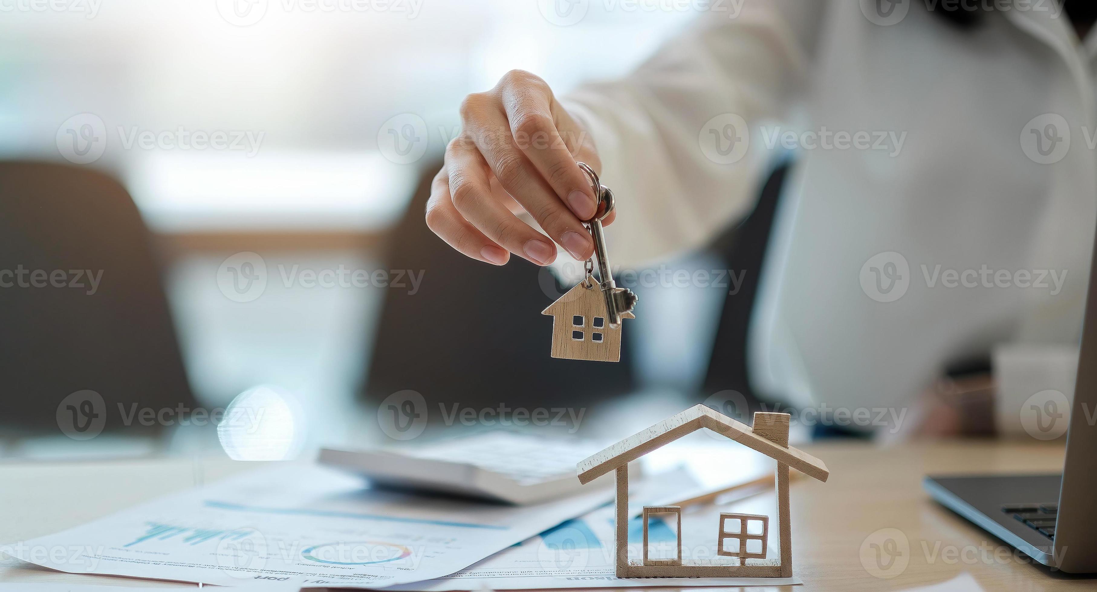 agente immobiliare che tiene la chiave di casa al suo cliente dopo aver firmato il contratto, concetto di immobile, trasloco o affitto di proprietà foto