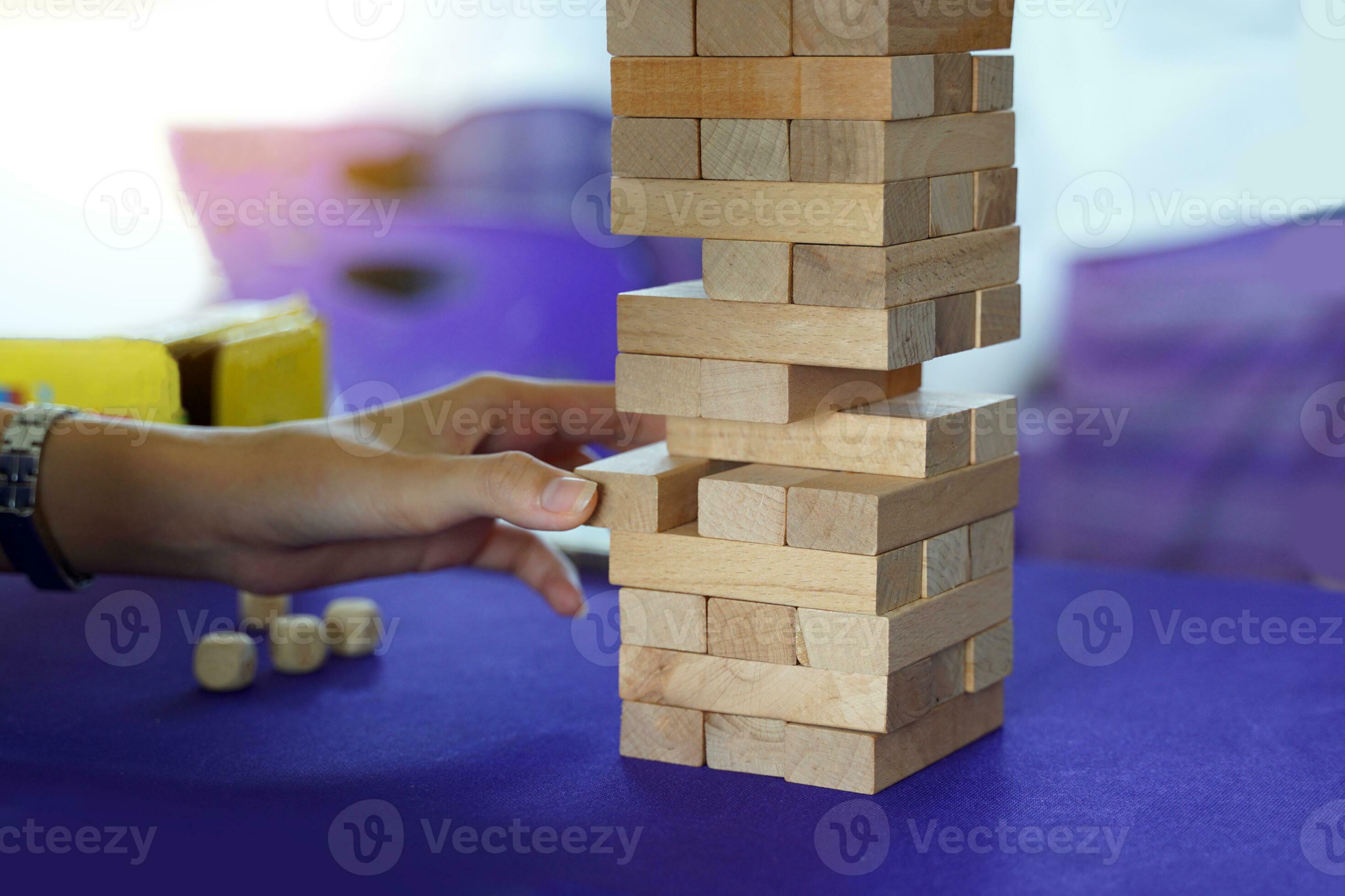 jenga è un' gioco nel quale di legno blocchi siamo impilati su per il  altezza di un' costruzione, poi ogni giocatore prende giri traino il  bloccare uno di uno con uno mano
