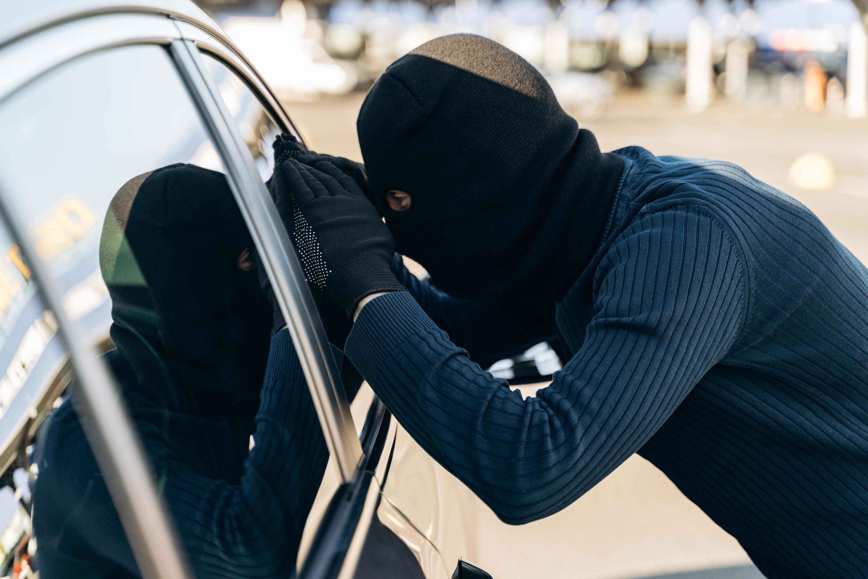 uomo vestito di nero con un passamontagna in testa guardando il