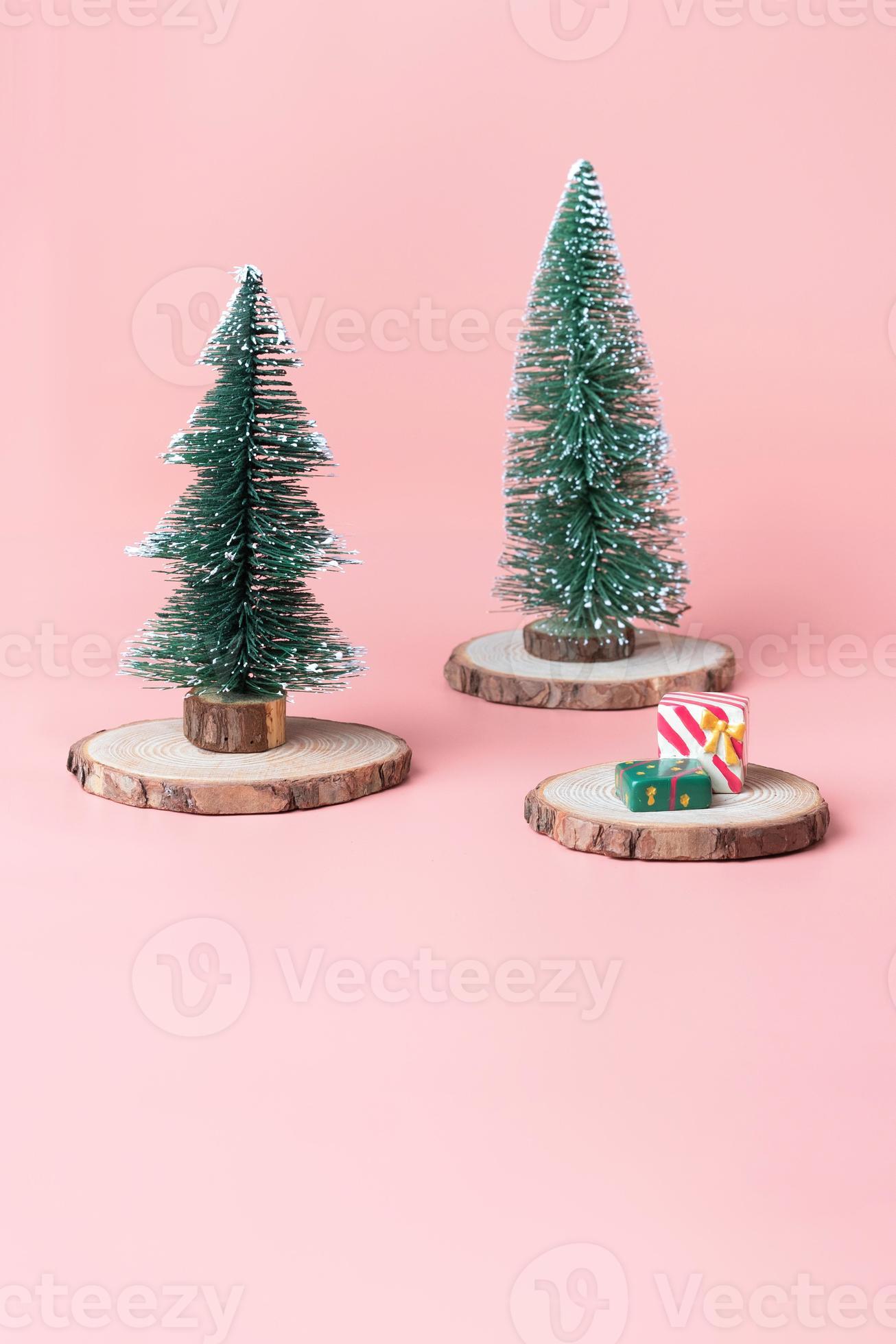albero di natale su fetta di tronco di legno con scatola regalo su rosa  pastello 4363816 Stock Photo su Vecteezy
