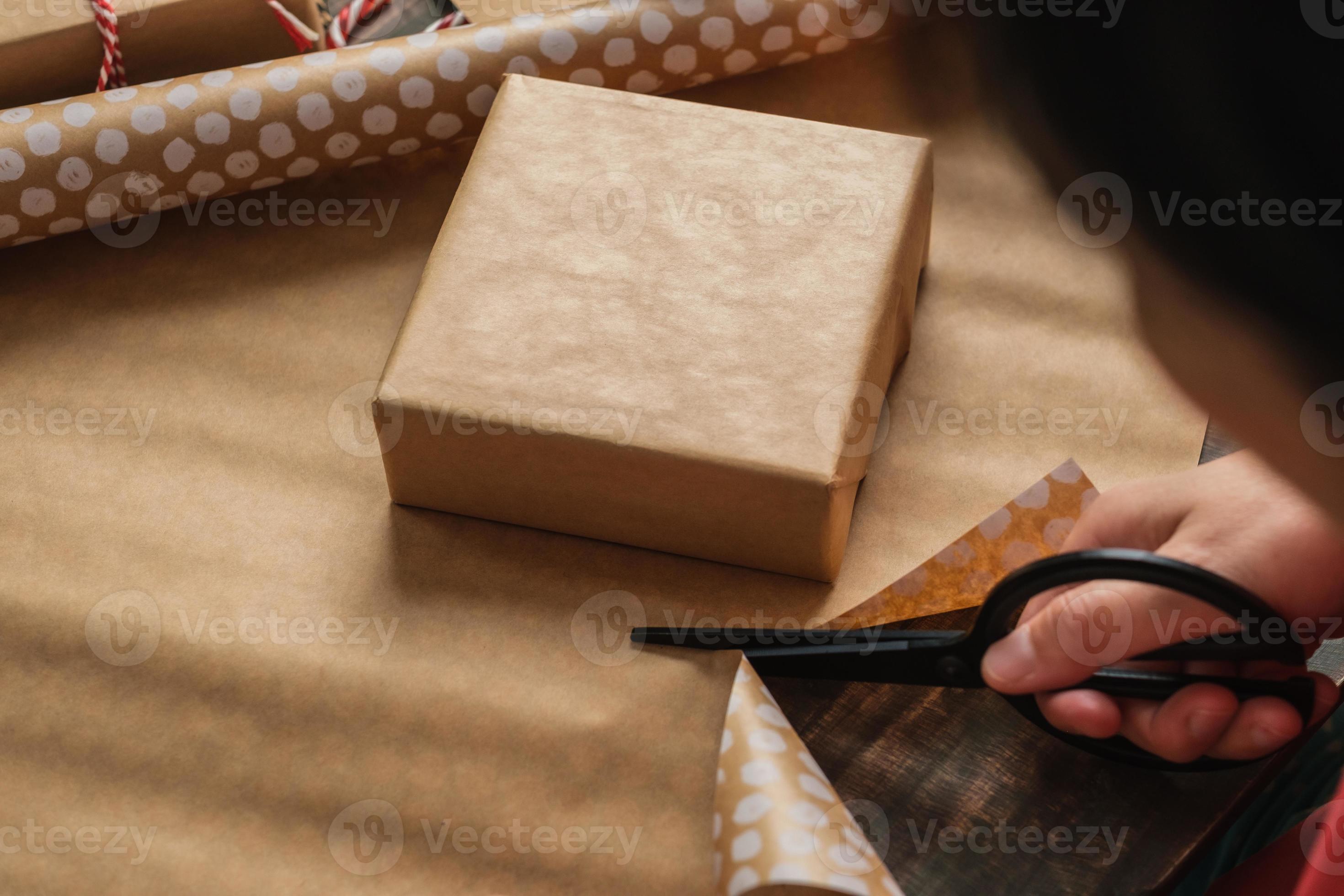 primo piano donna che taglia a mano la carta kraft per avvolgere la  confezione regalo di natale su un tavolo di legno 4773877 Stock Photo su  Vecteezy