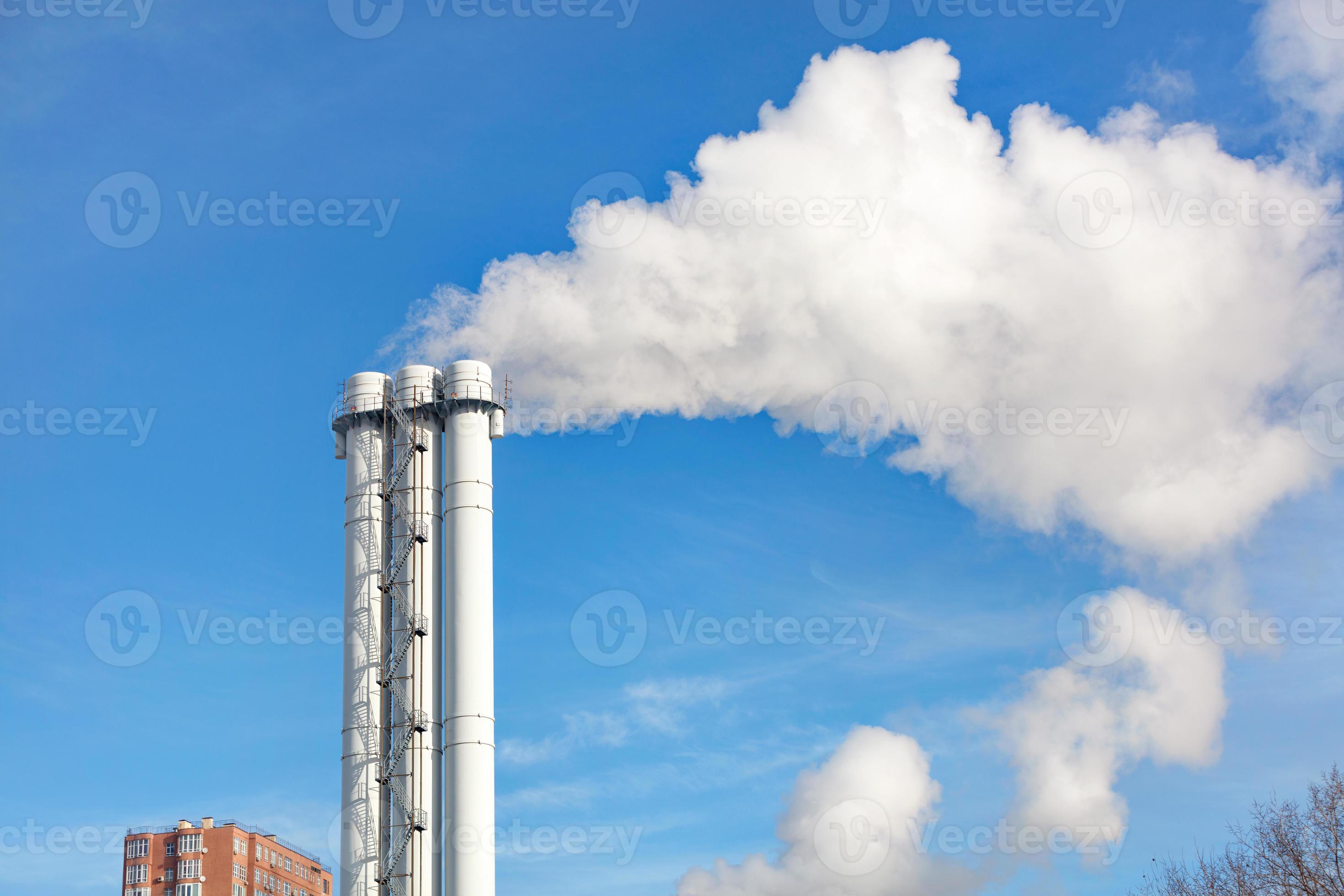 emissioni di fumo e vapore da un camino di cogenerazione in un cielo  sereno. 5433183 Stock Photo su Vecteezy