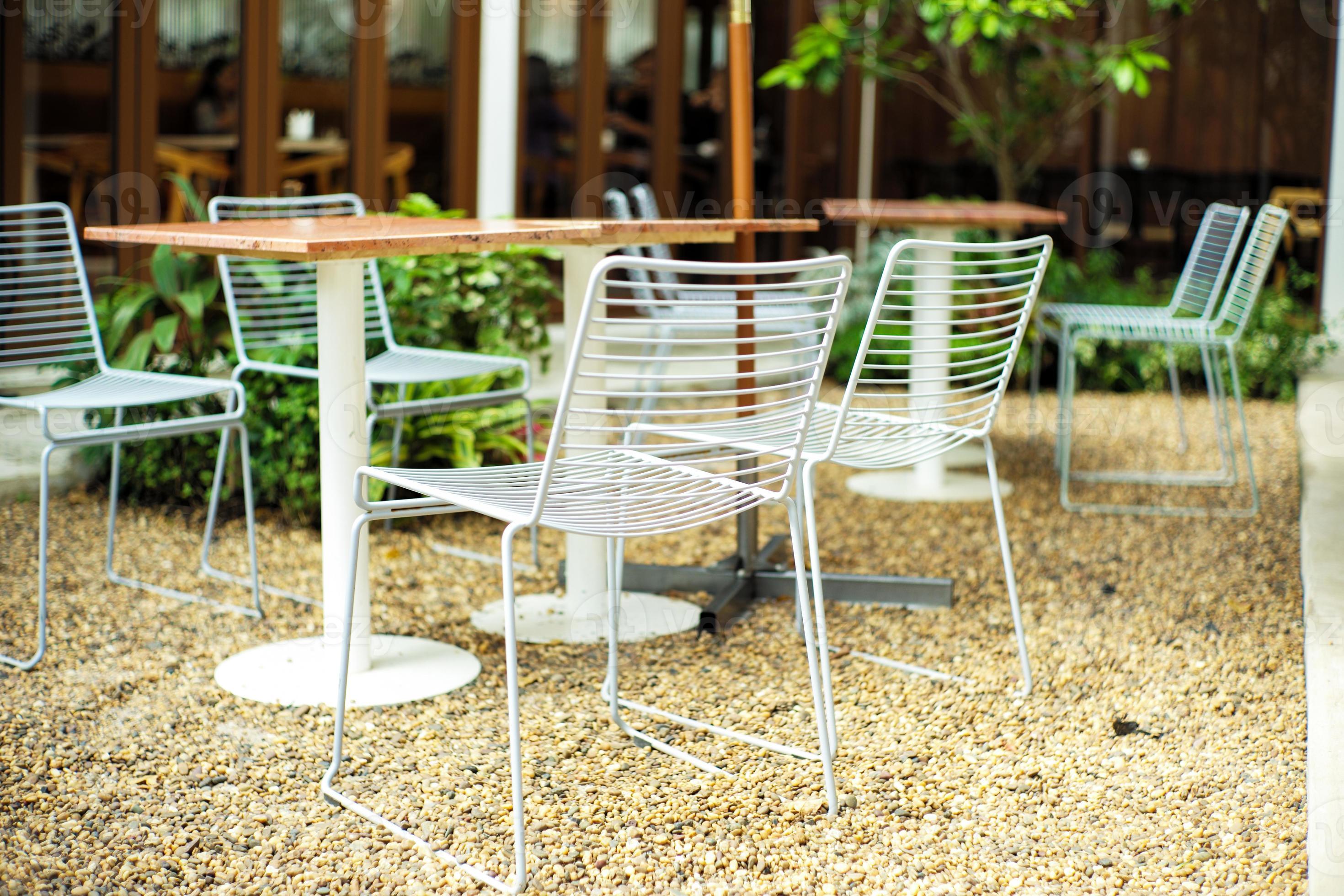 gruppo di primo piano di moderne sedie in metallo e tavolo di colore bianco presso il bar all'aperto foto