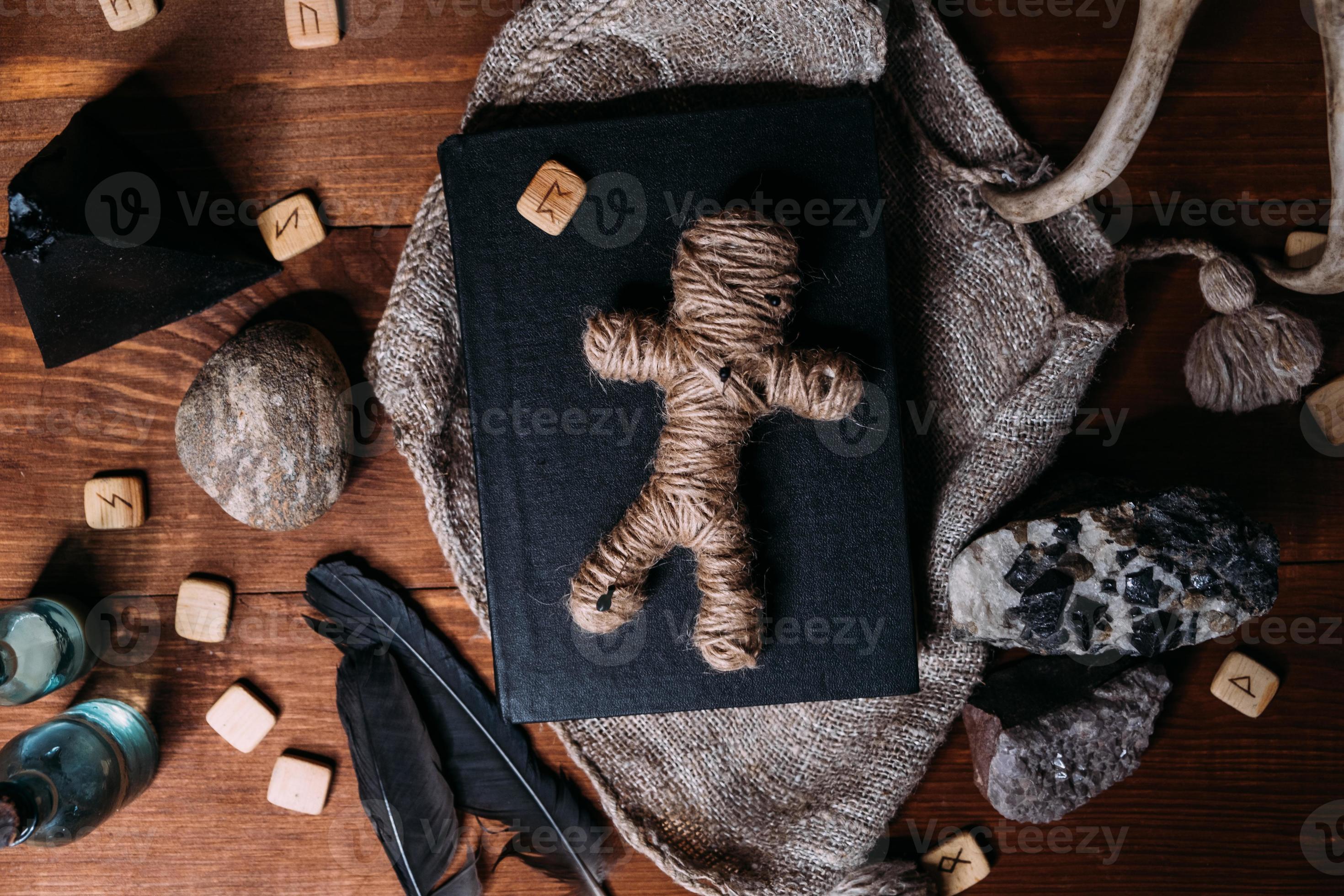 una bambola voodoo fatta di corda giace su un libro nero 7137297 Stock  Photo su Vecteezy