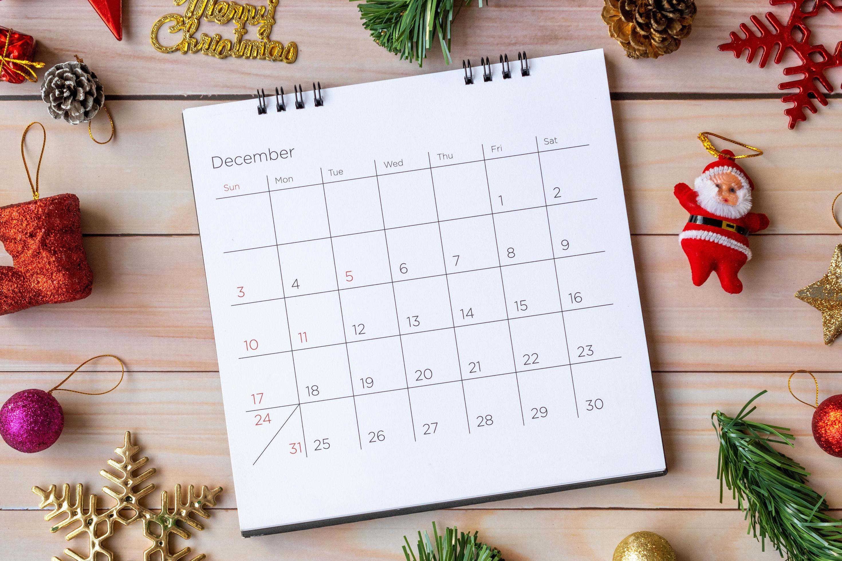 calendario di dicembre e decorazioni natalizie - Babbo Natale e regalo su tavola di legno. concetto di natale e felice anno nuovo foto