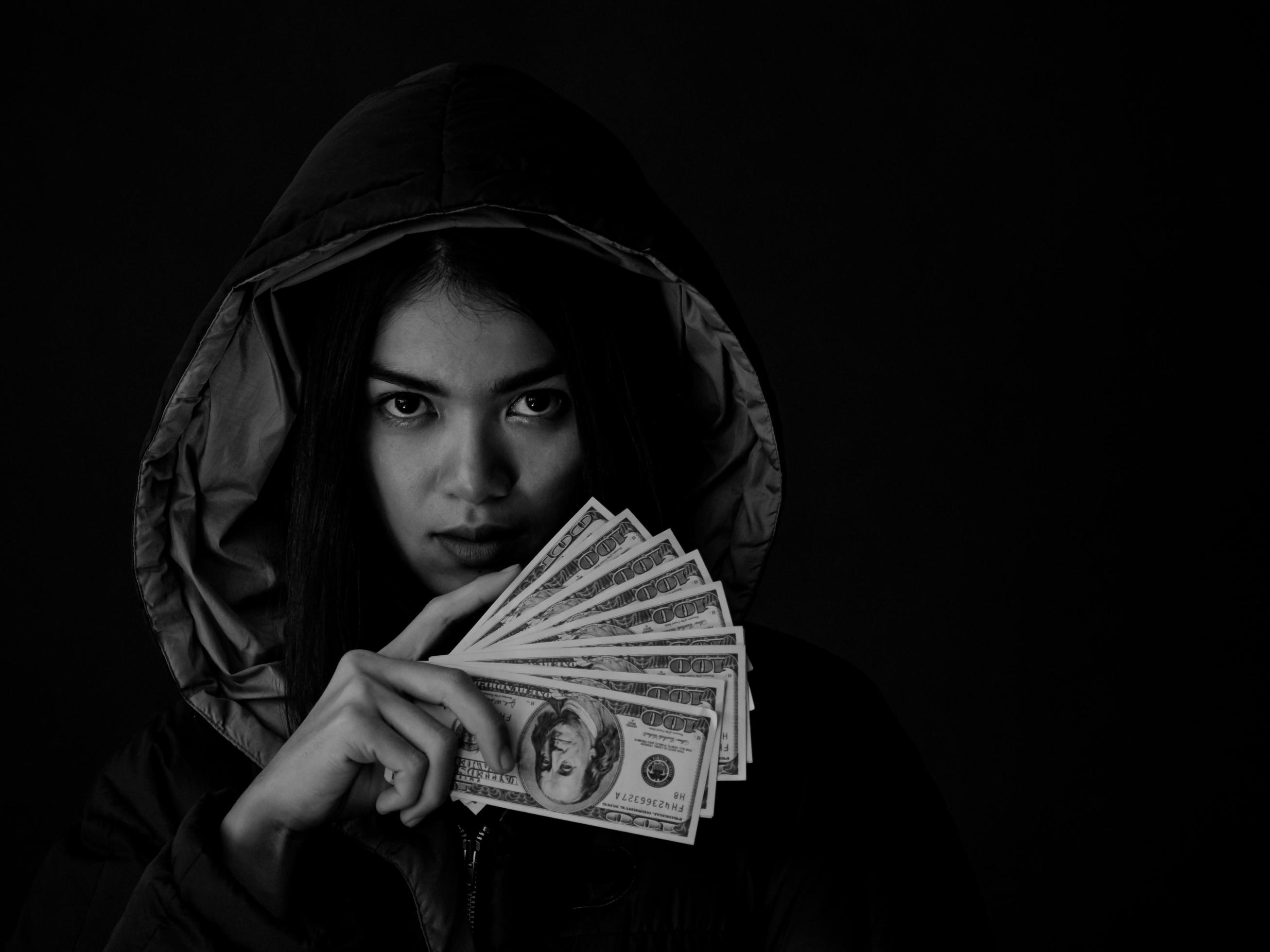 una giovane donna mostra molti dei soldi che ha guadagnato usando i metodi per cercare informazioni foto