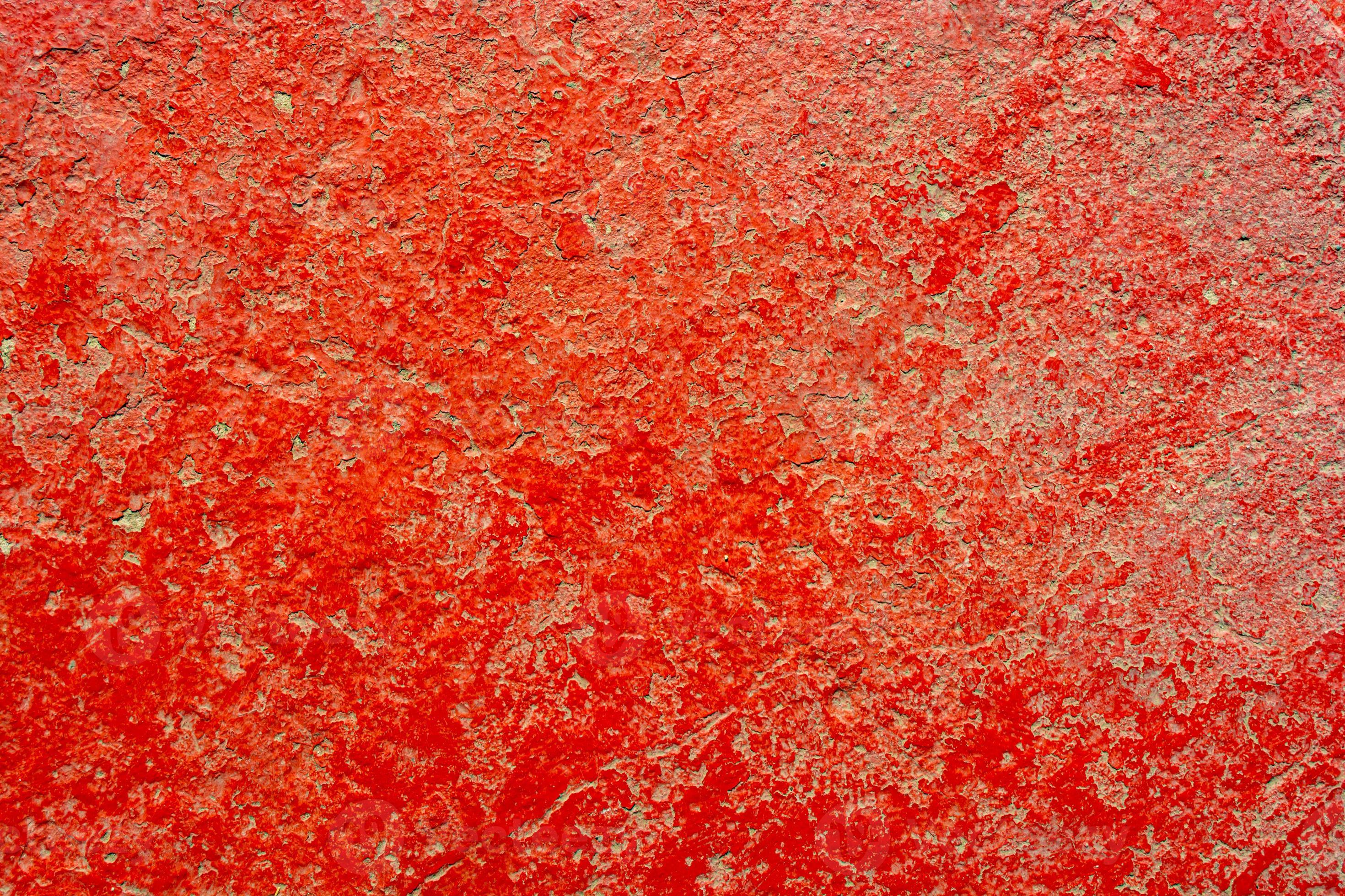 sfondo di vernice rossa incrinata su cemento grigio. foto