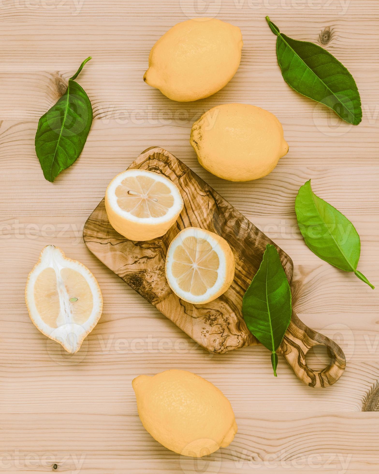 limoni freschi e foglie di limoni su fondo di legno rustico. limoni freschi  e fetta di limone su tavola di legno con disposizione piatta. sfondo di  agrumi freschi. 8376315 Stock Photo su