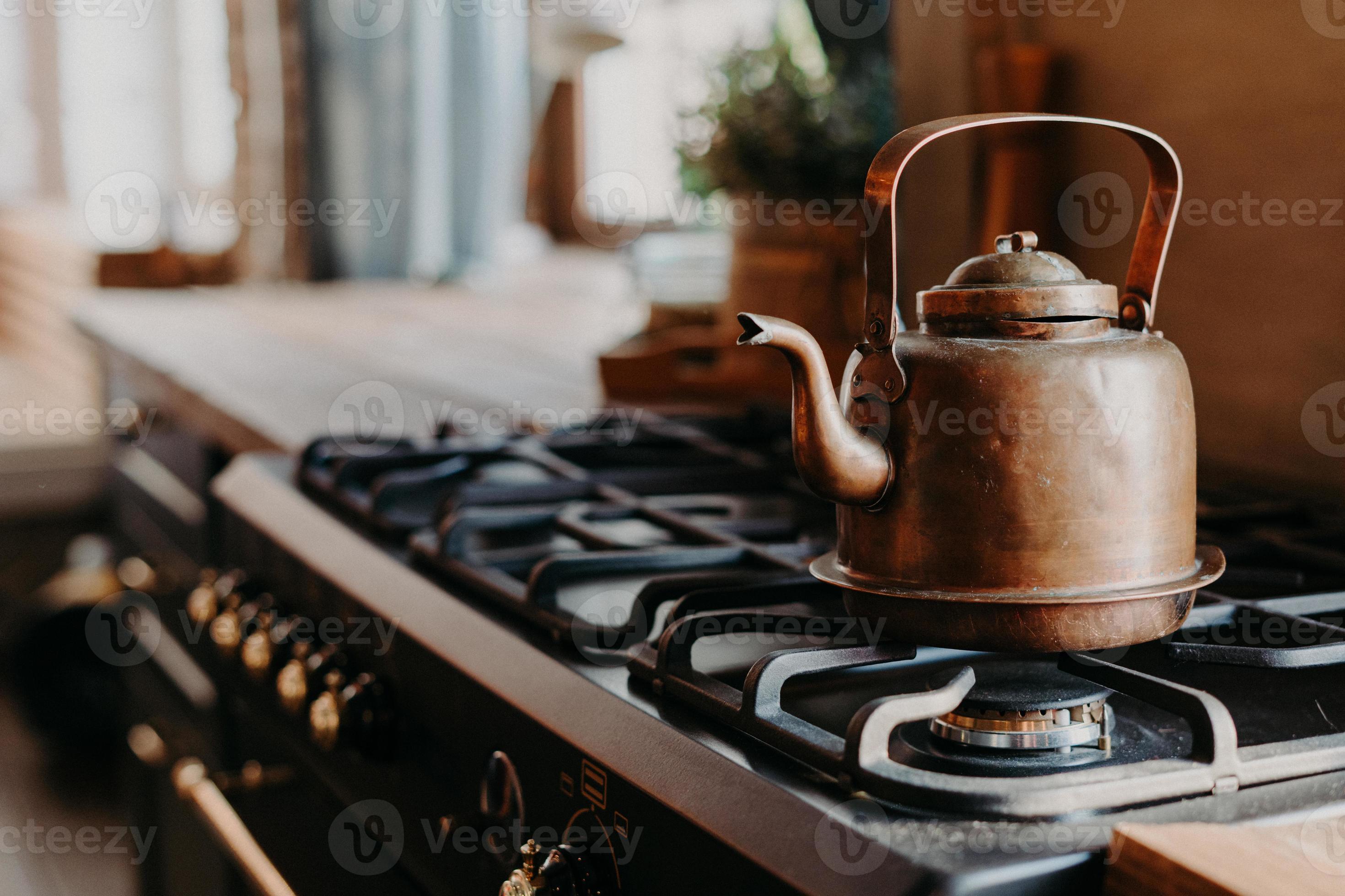 vecchio bollitore in alluminio che bolle sul fornello a gas in cucina su  uno sfondo sfocato accogliente. oggetto antico in metallo rame. stile  vintage 8828896 Stock Photo su Vecteezy