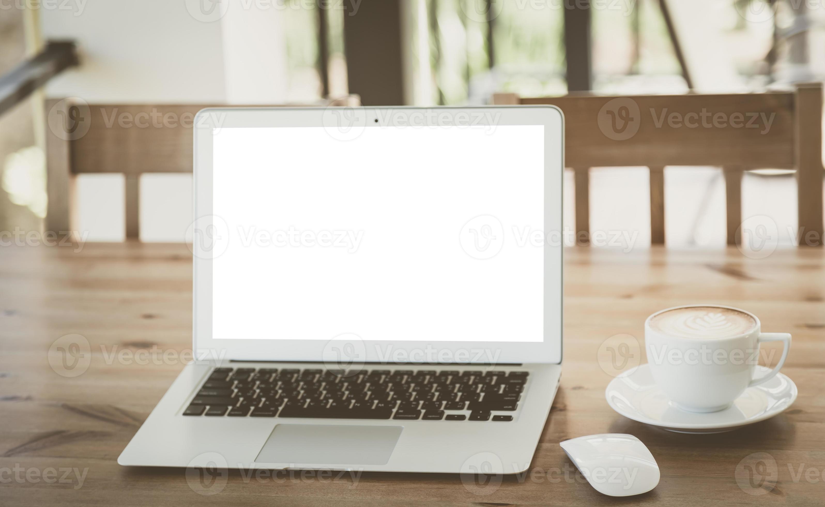 computer portatile con una tazza di caffè sul vecchio tavolo di legno foto