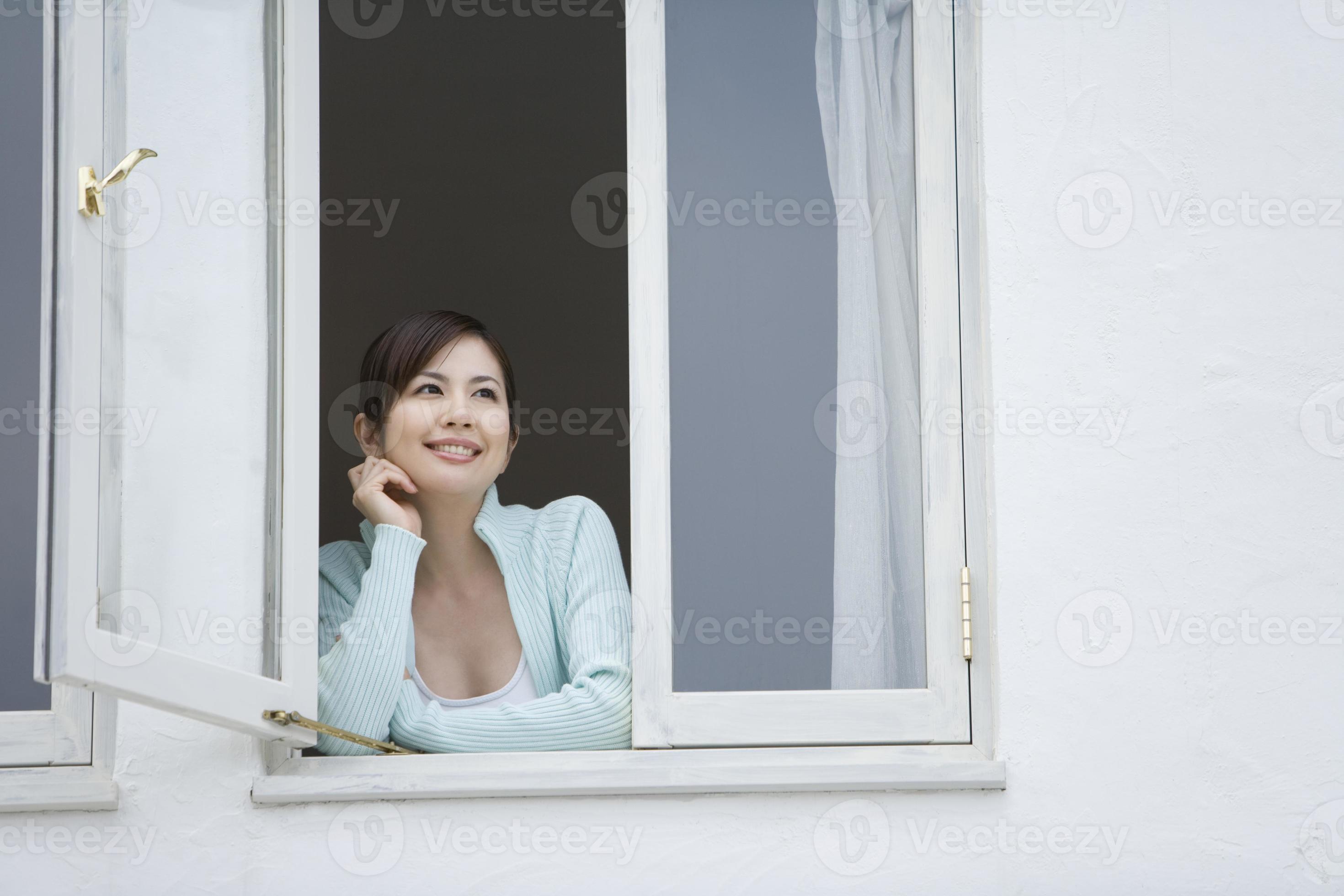 donna che sorride dalla finestra foto