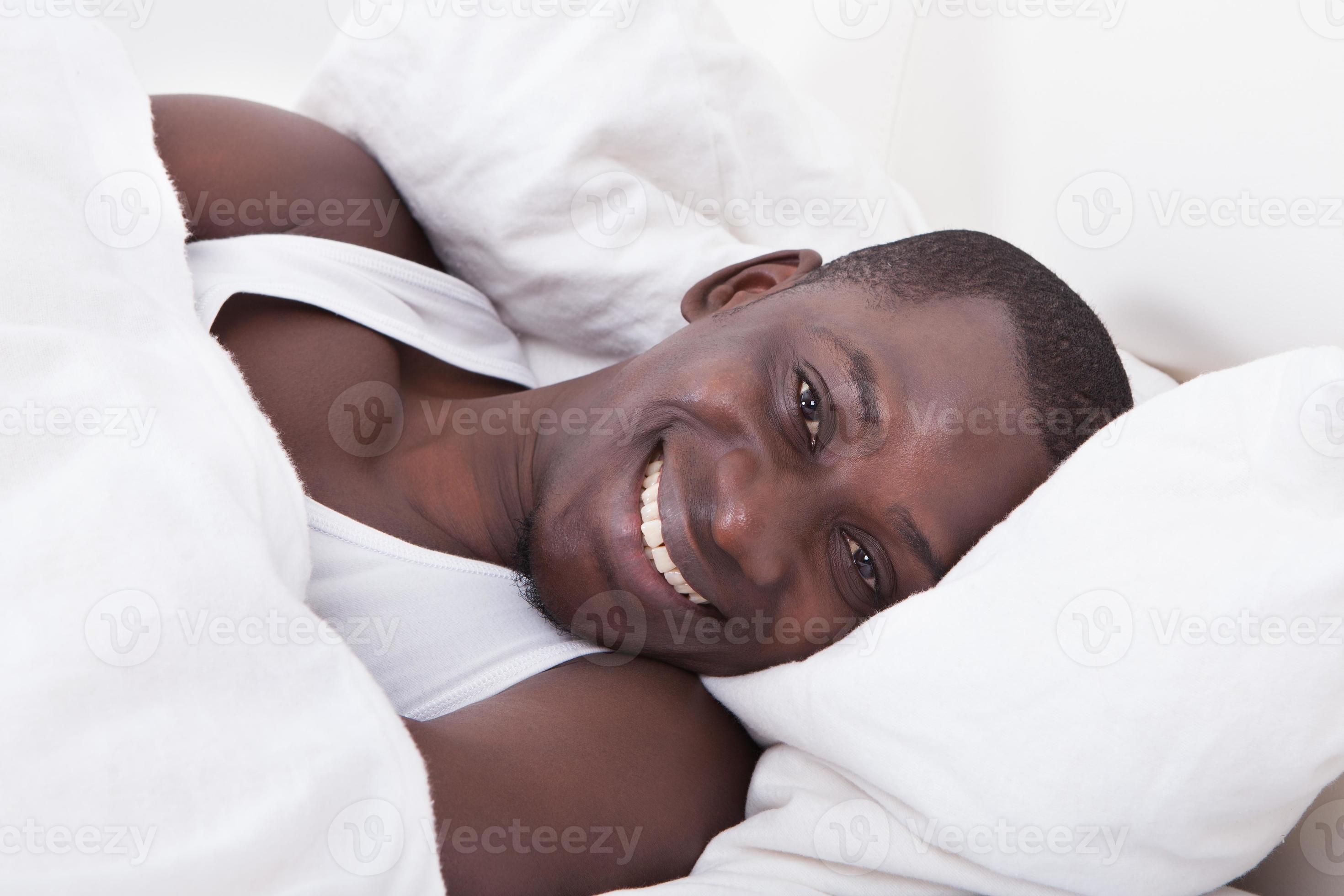 uomo africano sdraiato sul letto foto