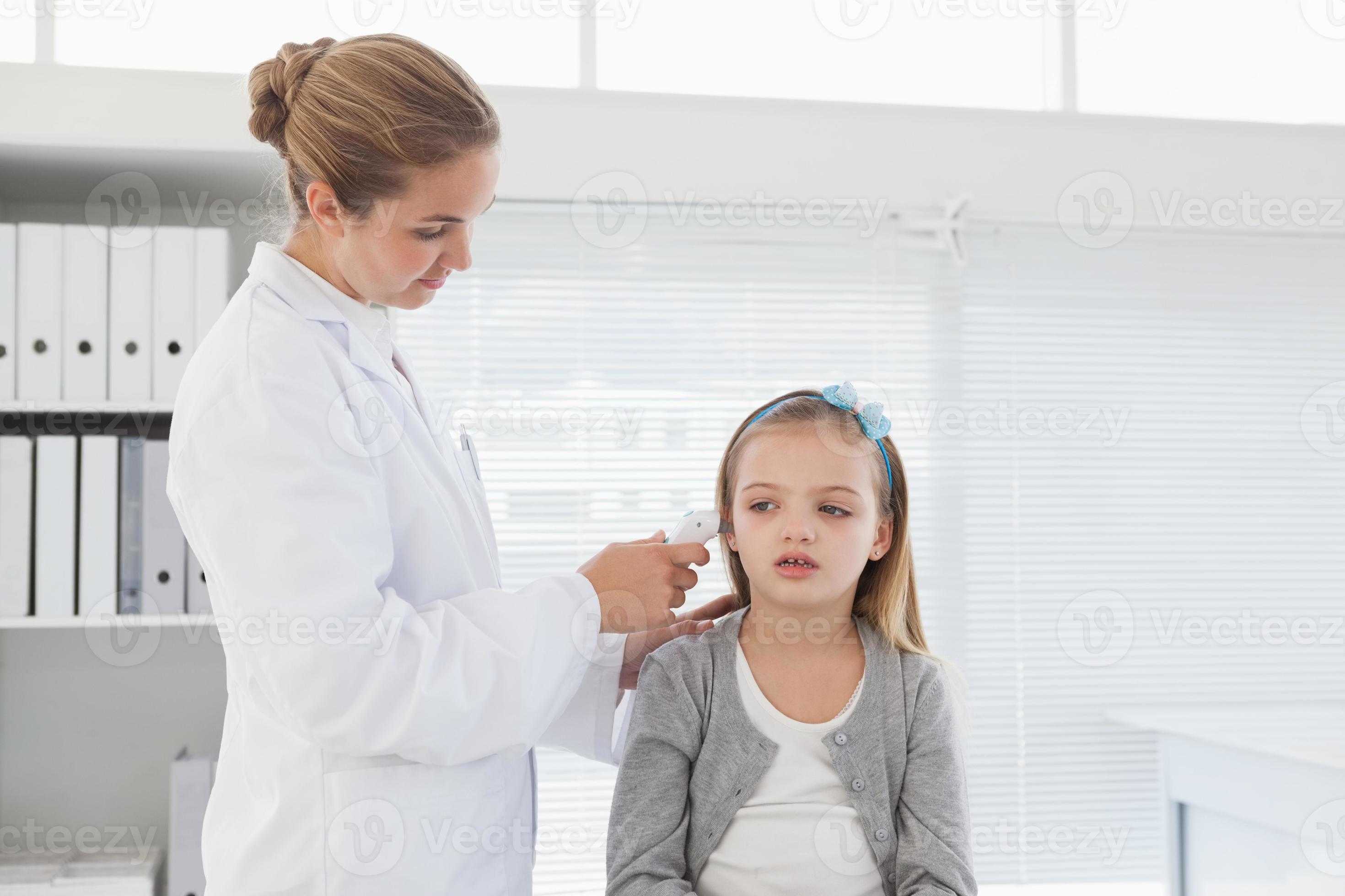 medico che controlla l'orecchio dei pazienti foto