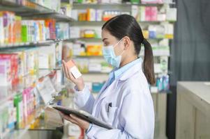 ritratto di una farmacista che indossa una maschera facciale in una moderna farmacia. foto