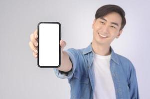 giovane uomo asiatico che utilizza smartphone su sfondo bianco, concetto di tecnologia. foto