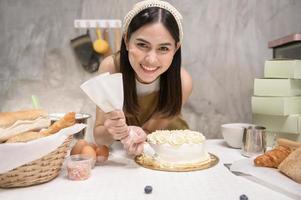 la giovane bella donna sta cuocendo nella sua attività di cucina, panetteria e caffetteria foto