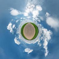 trasformazione del piccolo pianeta del panorama sferico a 360 gradi. vista aerea astratta sferica in campo in una bella giornata con bellissime nuvole fantastiche. curvatura dello spazio. foto
