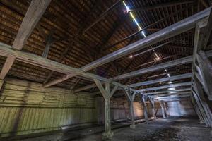 all'interno di un hangar in decomposizione di legno in rovina abbandonato scuro con colonne in decomposizione foto