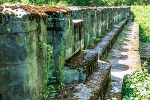 muro di muschio in cemento protettivo della fortezza militare abbandonata in rovina della prima guerra mondiale nella foresta foto