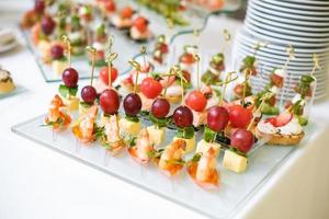 ristorazione. cibo fuori sede. tavolo da buffet con varie tartine, panini, hamburger e snack. foto