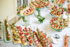 ristorazione. cibo fuori sede. tavolo da buffet con varie tartine, panini, hamburger e snack. foto