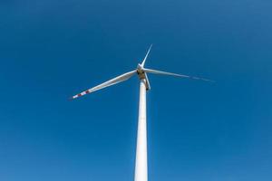 pale rotanti di un'elica di mulino a vento su sfondo blu cielo. produzione di energia eolica. pura energia verde. foto