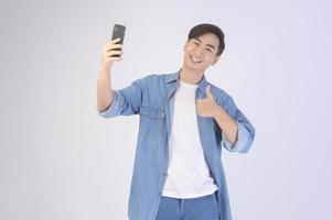 giovane uomo asiatico che utilizza smartphone su sfondo bianco, concetto di tecnologia. foto