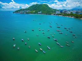 vista aerea della città di vung tau con un bel tramonto e tante barche. vista panoramica costiera di vung tau dall'alto, con onde, costa, strade, palme da cocco e montagna tao phung in vietnam. foto