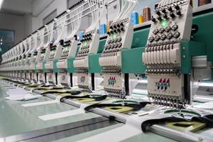 macchina da cucire moderna e automatica ad alta tecnologia per il processo di produzione di abbigliamento tessile o abbigliamento in ambito industriale. industria tessile digitale. ricamo computerizzato. foto