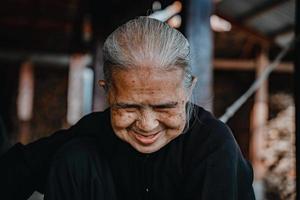 messa a fuoco vecchia donna con abito tradizionale vietnamita ao ba ba sorridente amichevole. primo piano del volto di donna. foto