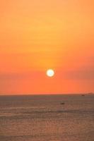 bellissimo paesaggio della spiaggia al tramonto, natura esotica dell'isola tropicale, cielo rosso giallo colorato, nave sagoma, riflesso dorato del sole, vacanze estive. cinematografia di nuvole di cielo. foto