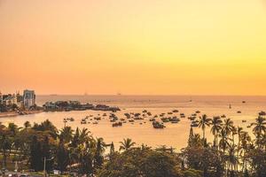 vista aerea della città di vung tau con un bel tramonto e tante barche. vista panoramica costiera di vung tau dall'alto, con onde, costa, strade, palme da cocco e montagna tao phung in vietnam. foto