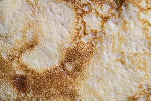 struttura e motivo della superficie del pancake. primo piano di sottili frittelle calde in un piatto. cibo rustico tradizionale. risorsa grafica. foto