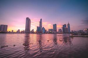 ho chi minh, vietnam - 13 febbraio 2022 vista dell'edificio della torre finanziaria di bitexco, edifici, strade, ponte thu thiem e fiume saigon nella città di ho chi minh al tramonto. immagine panoramica di alta qualità. foto