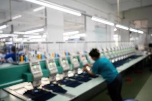 sfondo sfocato macchina da cucire moderna e automatica ad alta tecnologia per processi di produzione di abbigliamento tessile o abbigliamento in ambito industriale. industria tessile digitale. ricamo computerizzato. foto