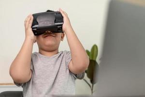 ragazzino asiatico con occhiali vr che studia scienze a casa, uno studente curioso indossa un auricolare per realtà virtuale per studiare scienze a casa studio online stile di vita futuristico apprendimento foto