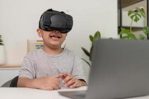 ragazzino asiatico con occhiali vr che studia scienze a casa, uno studente curioso indossa un auricolare per realtà virtuale per studiare scienze a casa studio online stile di vita futuristico apprendimento foto