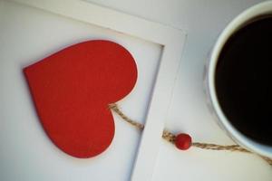 tazza d'amore, caffè con cuore rosso. cuore rosso su una corda nella cornice di legno. San Valentino. mattina. il 14 febbraio. foto