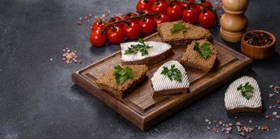 antipasto, baguette con pasta di fegato ed erbe aromatiche, primo piano. colazione fatta in casa foto