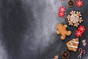 biscotti di pan di zenzero fatti in casa di natale su un tavolo di cemento scuro foto