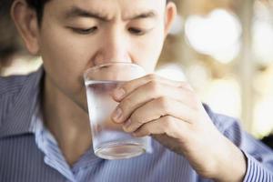 l'uomo beve acqua pura fredda fresca in vetro foto