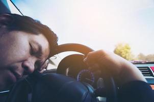 l'uomo dorme in macchina durante la guida su strada - le persone hanno provato da un lungo viaggio in auto e dal concetto di traffico foto