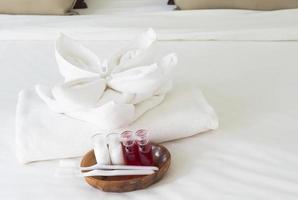 set di asciugamani per hotel con spazzolino da denti e dentifricio sul letto bianco foto